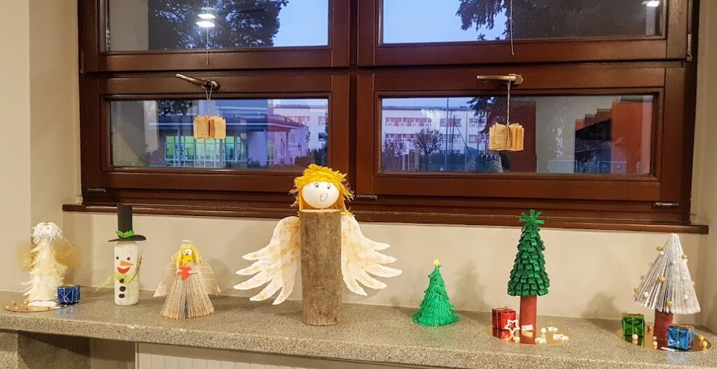 Na parapecie okna stoją anioły, bałwanki i choinki - prace wykonane przez dzieci