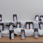Pingwiny z rolek po papierze toaletowym na wystawce przypominającej śnieg