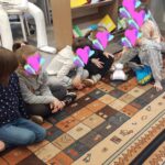 Uczniowie siedzą na dywanie i poznają robota