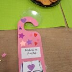 Różowa zawieszka na drzwi z napisem: Relaksuję się z książką
