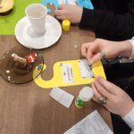 Uczestnicy wydarzenia tworzą zawieszki na drzwi