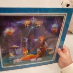 Dziecko pokazuje ułożone puzzle, które przedstawiają "Legendę o złotej kaczce".