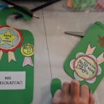 Zielone zawieszki na drzwi z kotylionami, na których są napisy: Tata na medal, Super tata #1, Tata mój bohater oraz naklejką: Nie przeszkadzać!