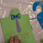 Laurka dla taty w formie zielonej koszuli z fioletowym krawatem i niebieską muszką. Z przodu napis LOVE