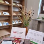 Książki Adama Mickiewicza rozłożone na stoliku i regale oraz pieczątka promująca Narodowe Czytanie.